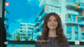 a woman is smiling in front of a screen that says hum hd on it
