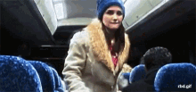 a woman wearing a blue hat is standing in a bus