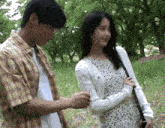 a man and a woman are standing in a grassy field