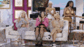 a group of women are sitting on a couch laughing