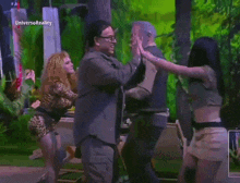 a group of people are dancing in front of a screen that says " universo reality "