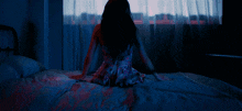 a woman laying on a bed in front of a window