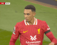 a soccer player wearing a red shirt with futuremakers on it