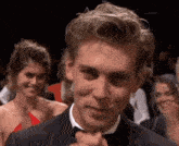 a man in a tuxedo is making a funny face