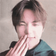 a young man covering his mouth with his hands