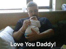 a man is holding a baby with the words love you daddy written above him