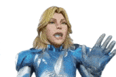 a woman in a blue and silver superhero costume is making a stop gesture .