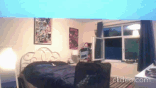 a bedroom with a bed and a window with the words clideo.com on the bottom right
