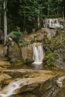 a waterfall is surrounded by rocks and trees in a forest