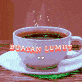 a cup of coffee on a saucer with the words buatan lumut on it