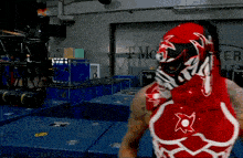 a man in a red and white wrestling outfit stands in front of a t mobile sign