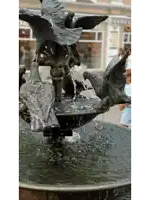 a fountain with a statue of birds and a sign that says ' s ' on it
