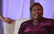 a woman wearing a purple shirt that says our