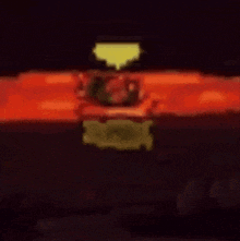 a blurred image of a person holding a torch in front of a red background .