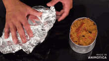 a person is wrapping a piece of aluminum foil around a container of food that is made in animatica