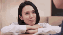 a woman is sitting at a table with her hands on her face
