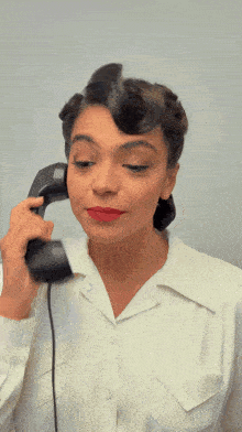 a woman with red lipstick is talking on a phone