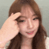 a blurry picture of a woman 's face with her finger on her forehead