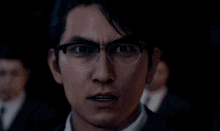 a close up of a man 's face with glasses