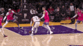 a basketball game is being played on a purple court .