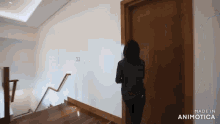 a woman is standing in a hallway next to a door .