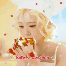 a woman in a chef 's hat is eating a donut with the words kotoko de jowi written on the bottom