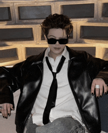 a man wearing sunglasses and a leather jacket