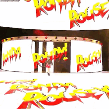 a woman is walking in front of a large screen that says ronda rousey on it