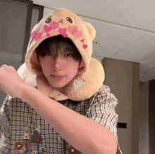 a young man wearing a teddy bear hat and a neck pillow