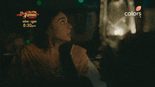 an advertisement for colors shows a woman in a dark room looking at something