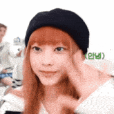 a woman with red hair wearing a black hat with a green sticker that says ' oh ' on it