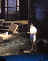 a man in a white shirt is standing on a stage in front of a chair with the letter j on it