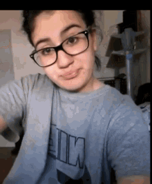 a girl wearing glasses and a t-shirt that says ' pink ' on it