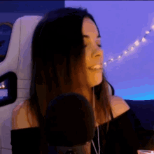a woman is sitting in a chair with a microphone in front of her .