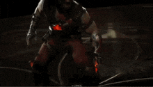 a man in a red suit is holding a red knife in his hands .