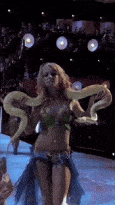a woman in a green top is holding a snake