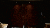 a man in a suit and tie is walking through a dark room