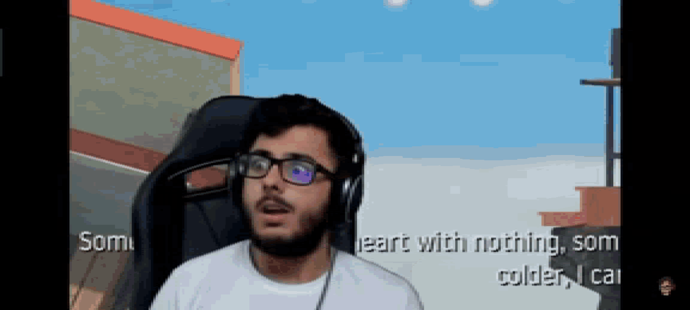 a man wearing glasses and headphones is sitting in front of a screen that says som on it