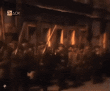 a blurred image of a group of people with a 24 aok sign above them