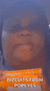 a woman is eating a biscuit from popeye 's and making a funny face .