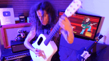 a man playing a guitar in front of a screen that says ' guitar ' on it