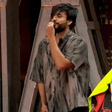 a man with a beard is wearing a dirty shirt and has a microphone in his mouth