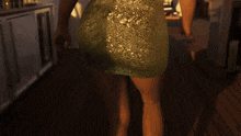 a woman in a green dress is standing on a deck