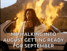 a woman is standing in front of a car that is on fire