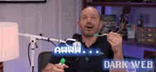 a man is holding a toothbrush in front of a microphone with the words awww dark web above him