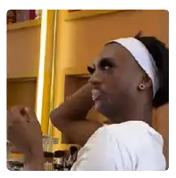 a man wearing false eyelashes and a headband is looking at himself in the mirror