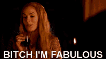 a woman holding a glass of wine with the words bitch i 'm fabulous below her