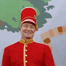 a man in a red uniform with a red hat smiles