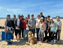 a group of people posing for a picture on a beach