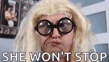 a man wearing glasses and a wig with the words she won 't stop behind him